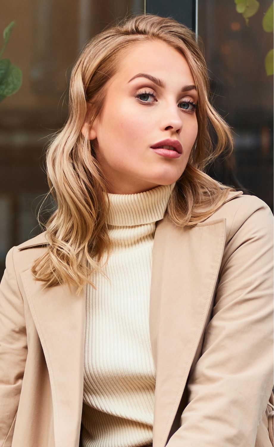 Woman with wavy hair in stylish outfit.