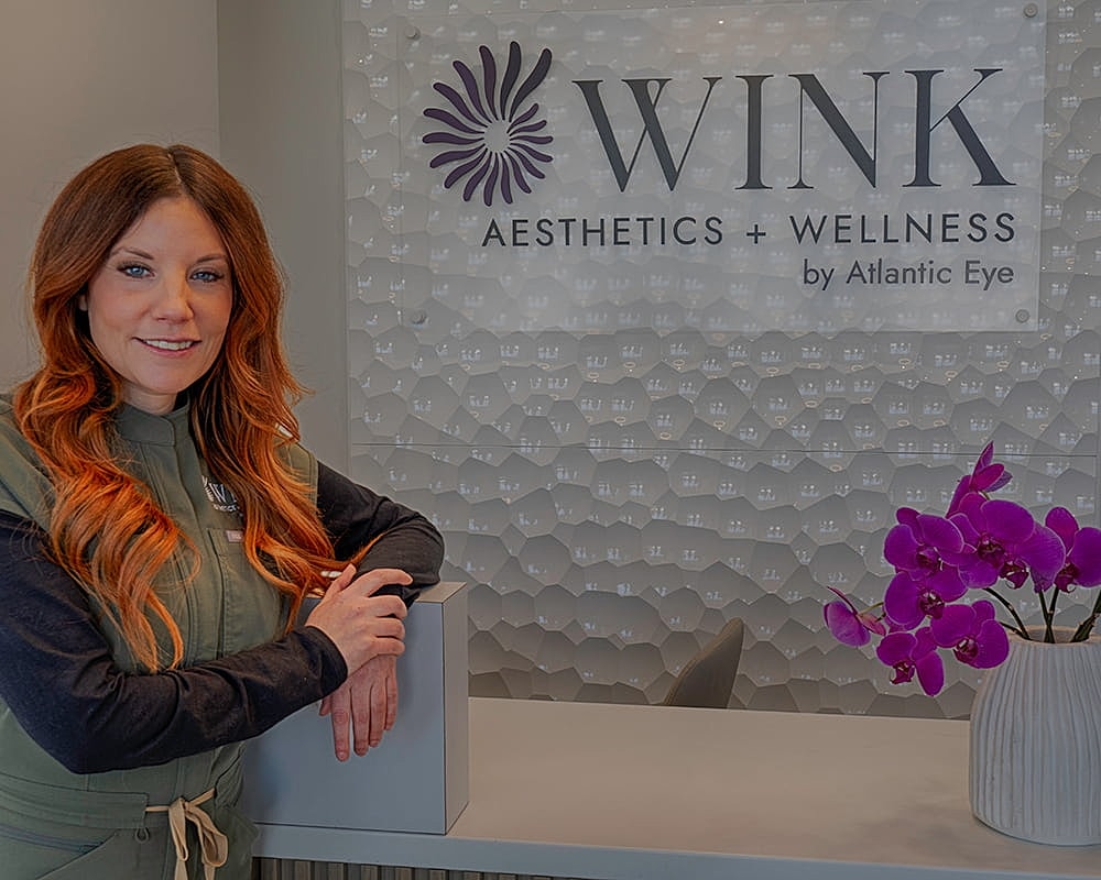 Woman at WINK Aesthetics + Wellness reception.