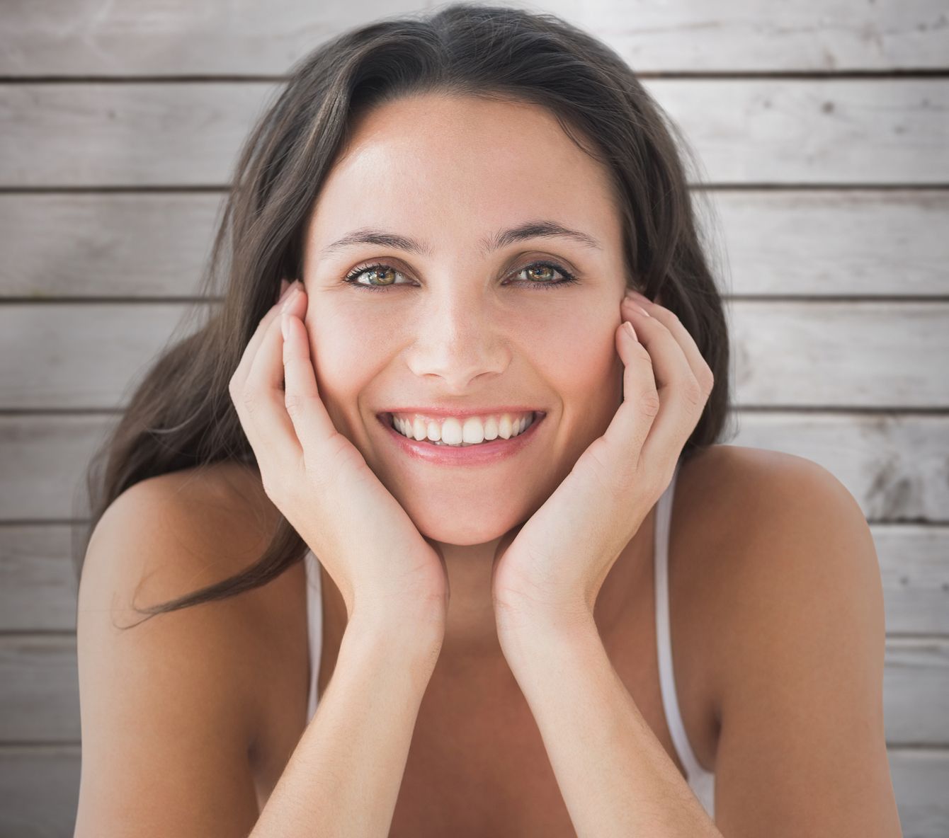 Smiling woman with hands on cheeks.