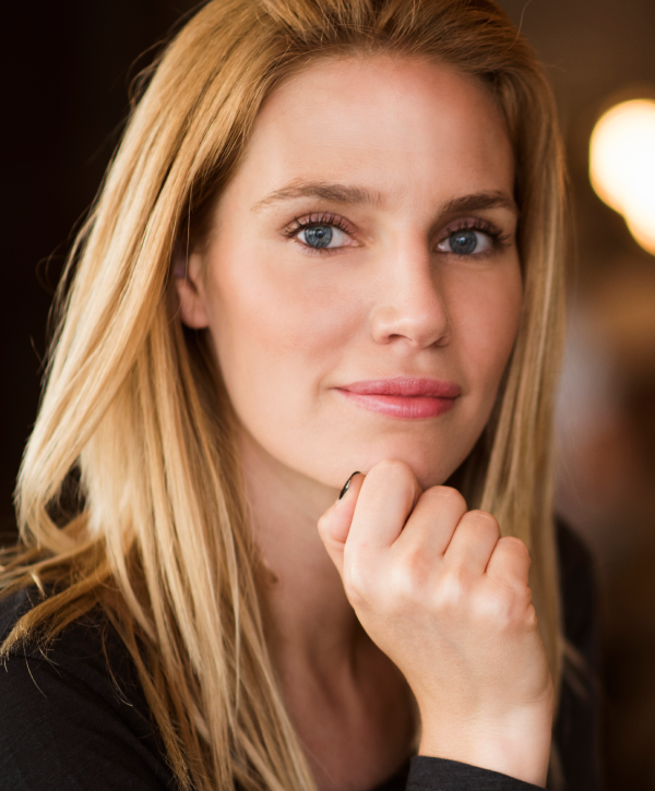 Smiling woman taking a selfie outdoors.