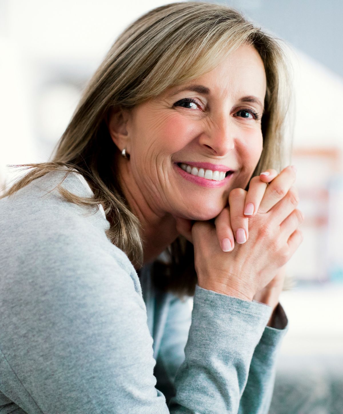 Woman with long hair, natural makeup, thoughtful expression.