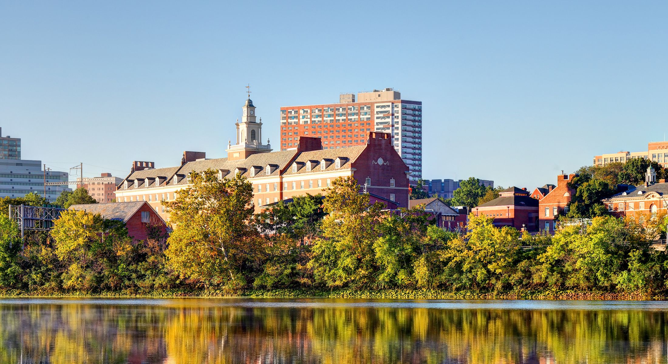Cityscape with buildings reflecting on water.