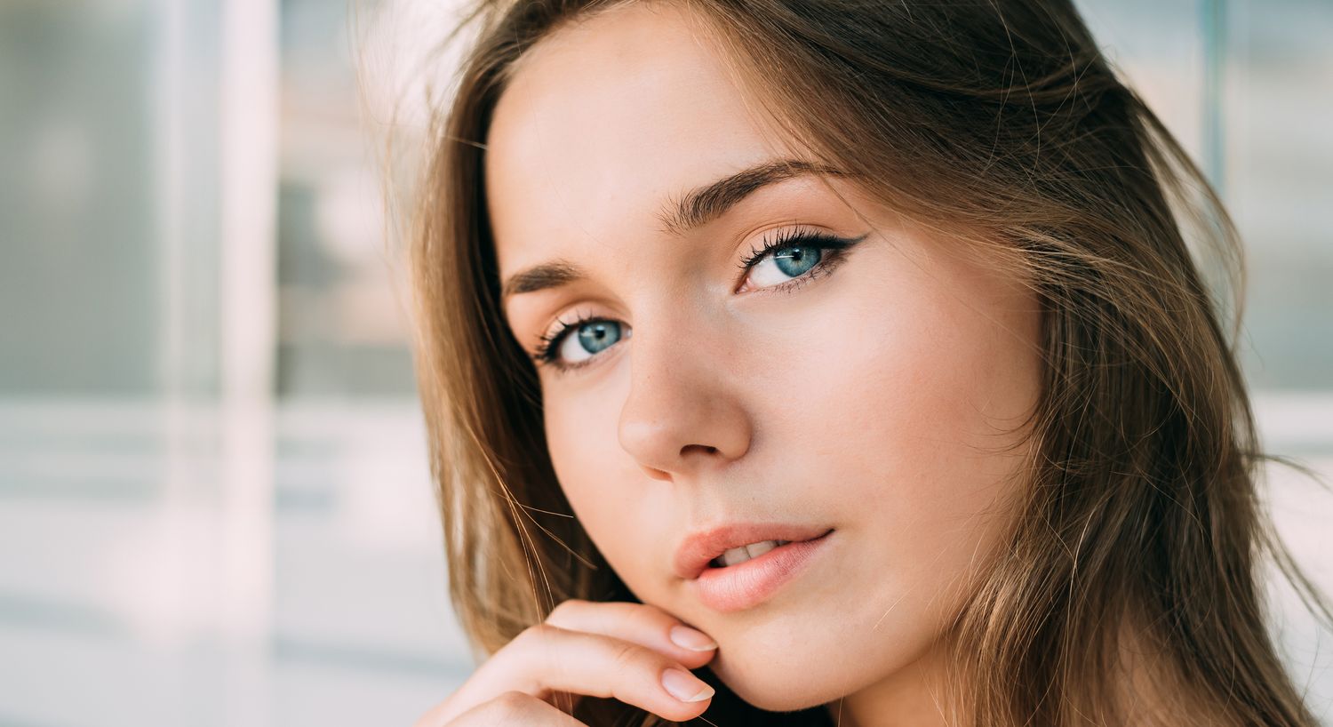 Close-up of a woman with striking blue eyes.